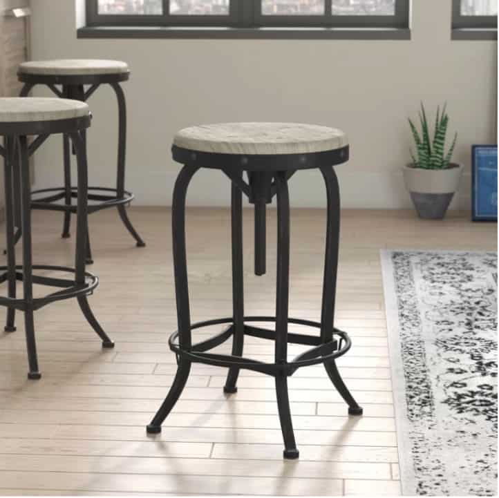 Industrial counter stool with black metal legs and white wood seat.