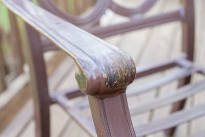 Metal outdoor patio chair with chipping paint.