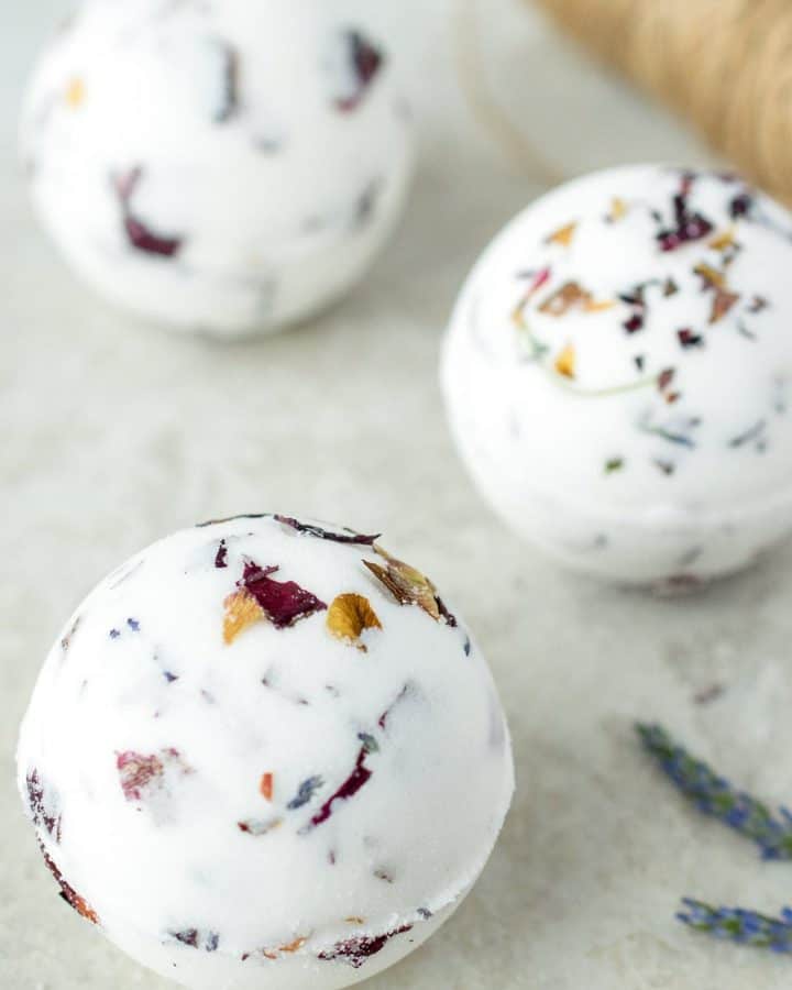 3 Homemade bath bombs with rose petals and lavender inside.