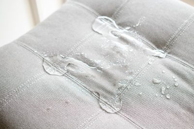 Water beading on fabric after spraying with water repellant.