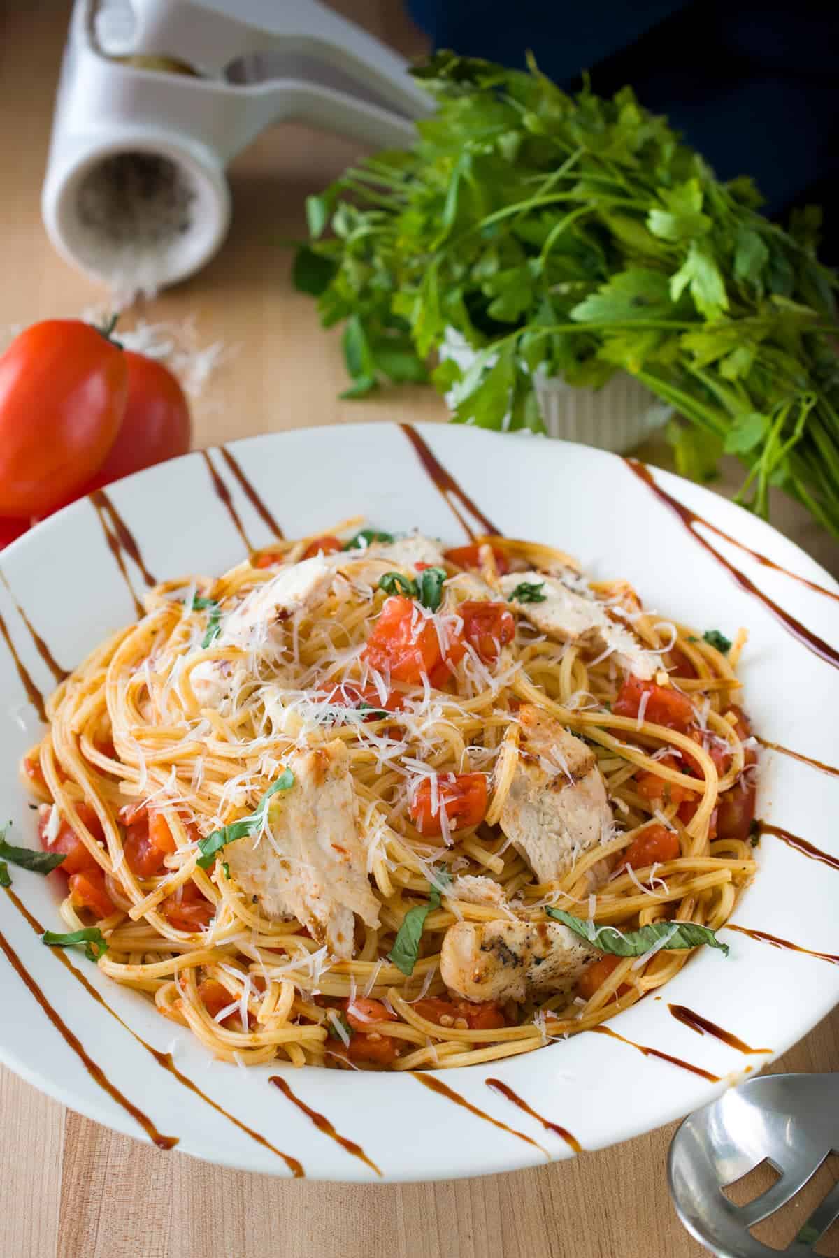 TGI Friday Copycat Bruschetta Chicken Pasta Recipe in a white bowl with basil and Parmesan garnish.