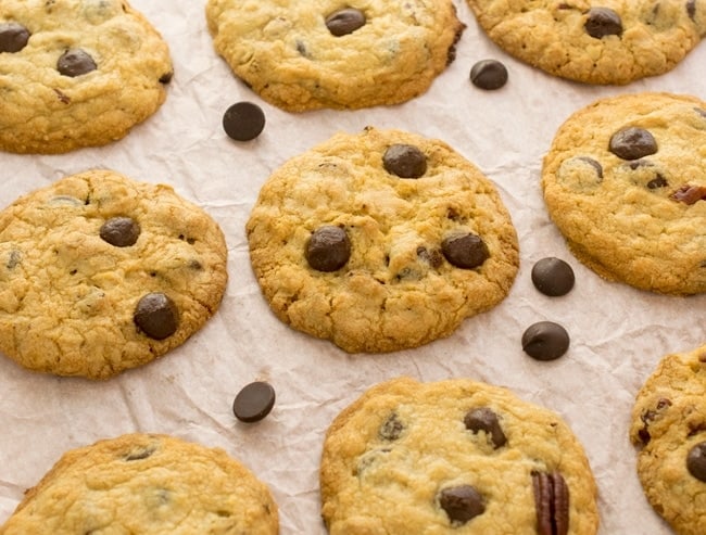 Chocolate Chip Cookies with pecans laid out to cool on wax paper.