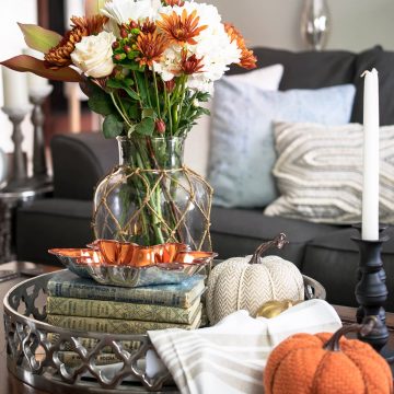 Coffee Table Fall decor vingette featuring flowers, pumpkins, candles, and old books.