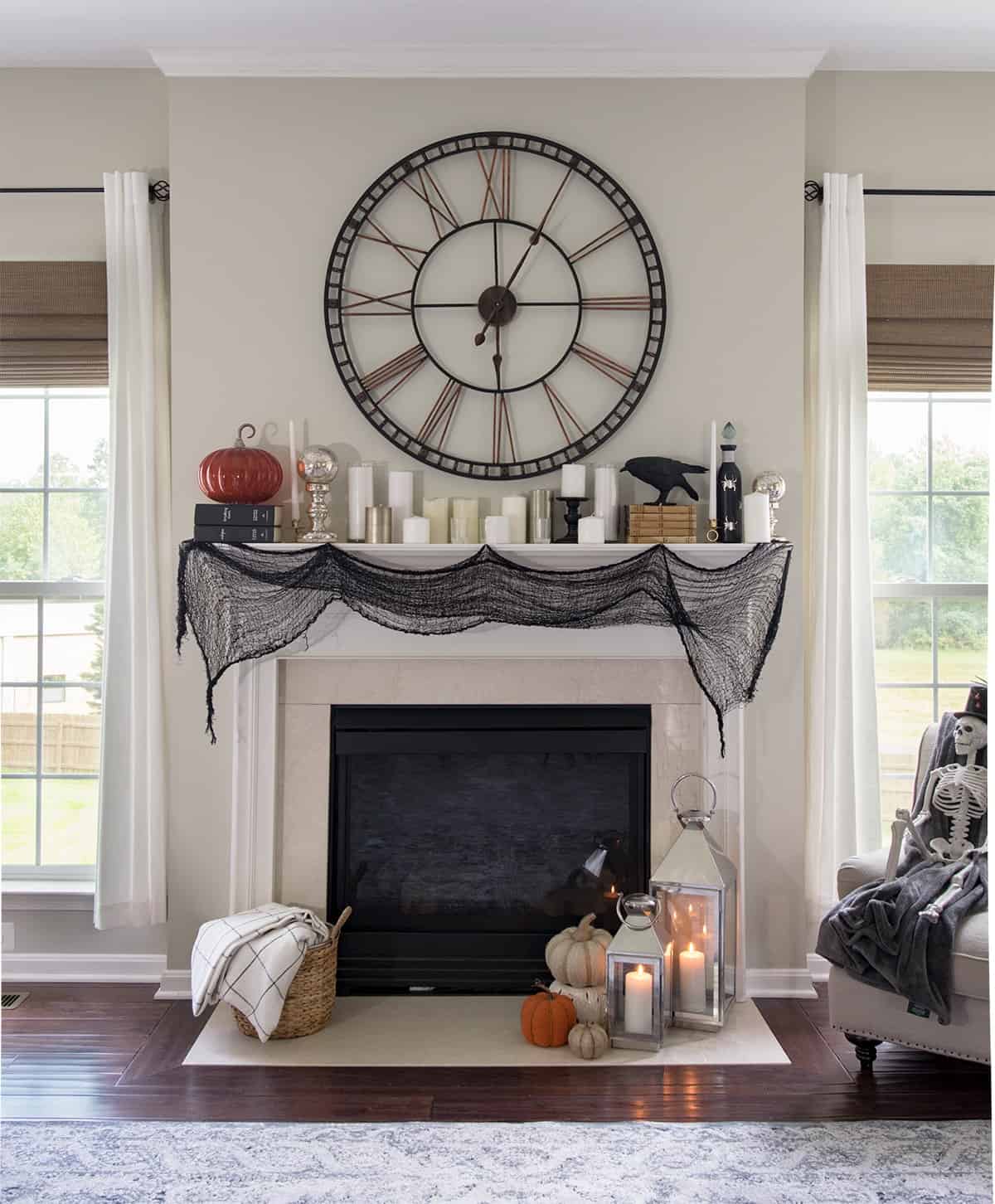 Fall Halloween mantle with giant clock, old books, and scarf garland.