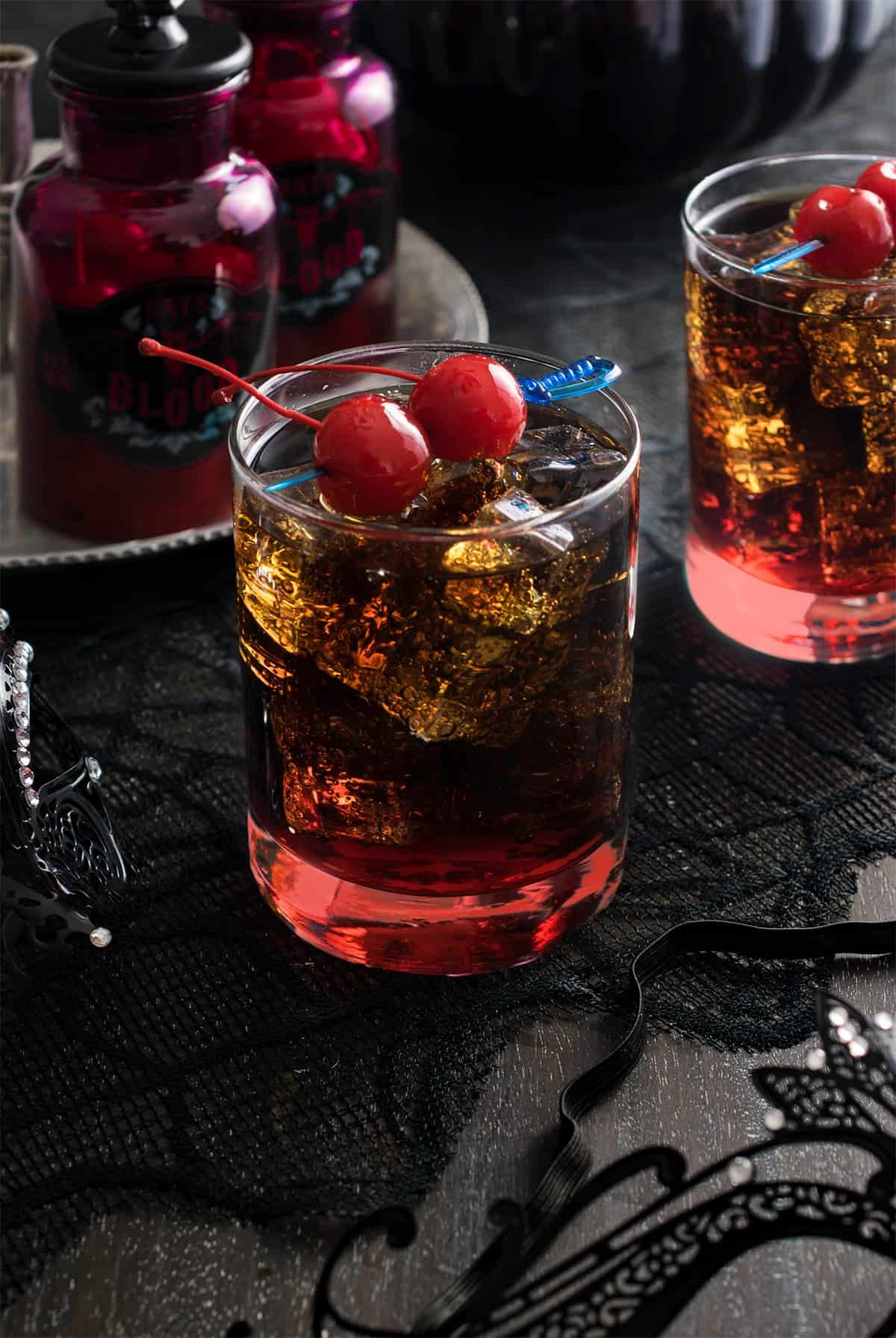 Rum and Coke Halloween Cocktail with red cherry garnish and grenadine