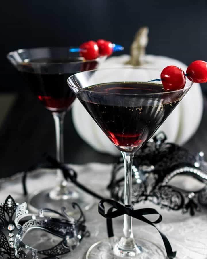Rum and coke in a martini glass with marchino cherry garnish.