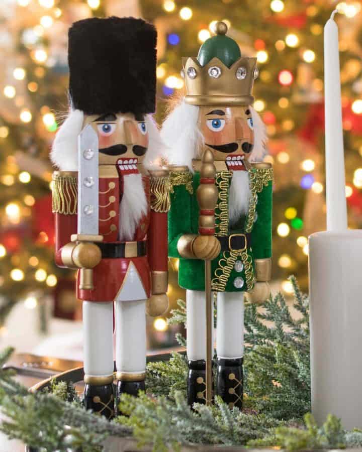Two nutcracker princes standing in front of a Christmas tree.