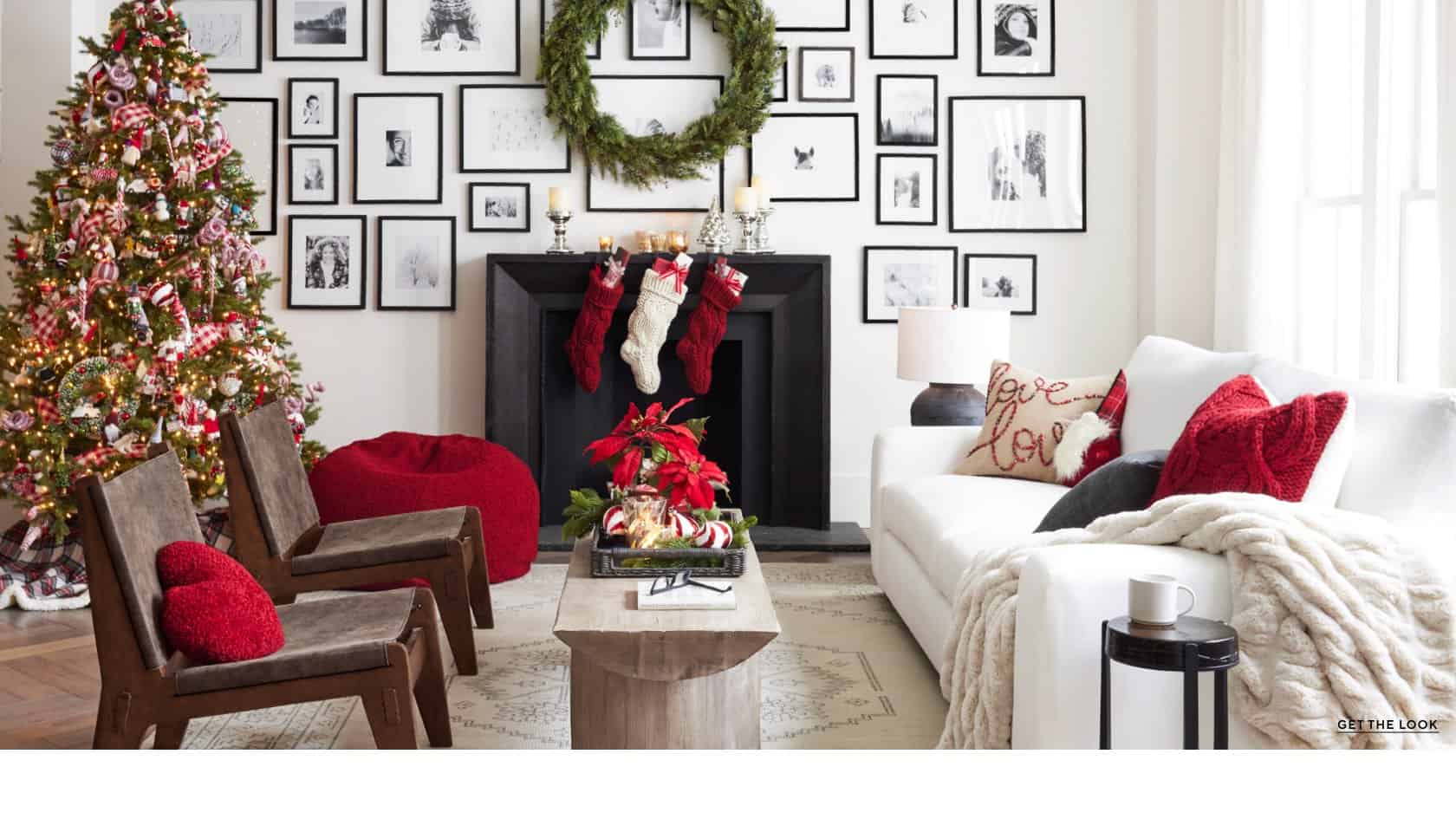 Red and white christmas living room with nostalgic accents, white furniture and a gallery wall of photos.