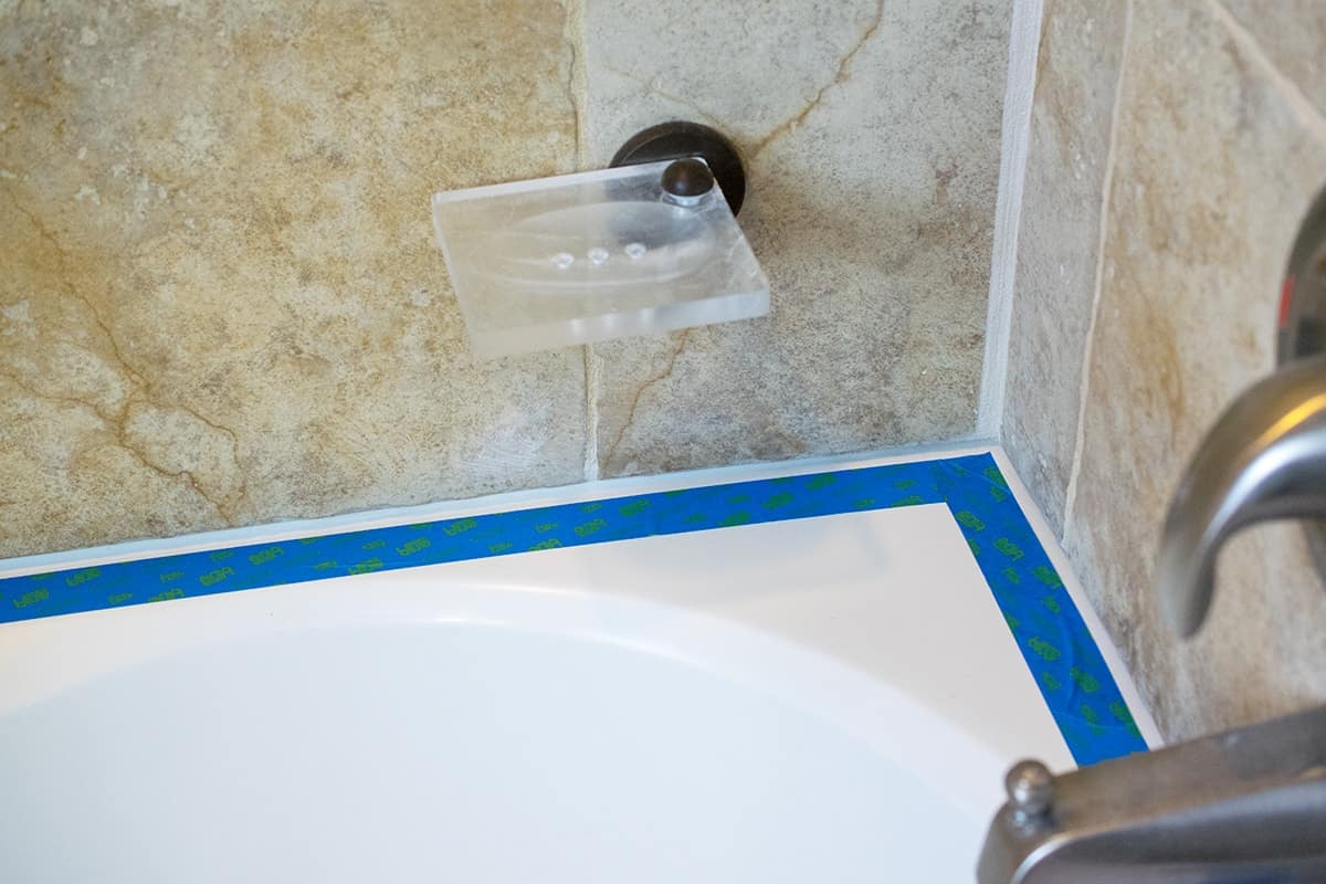 Demonstration of how to tape a bathtub for caulking.