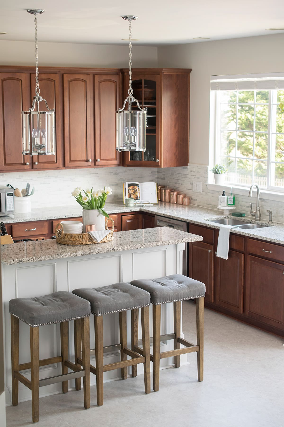 Traditional Kitchen Decorating and Remodel. This grey kitchen includes white granite, dark cabinets, marble backsplash, and a two level island.