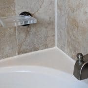 Freshly added caulk to a bathtub surround.