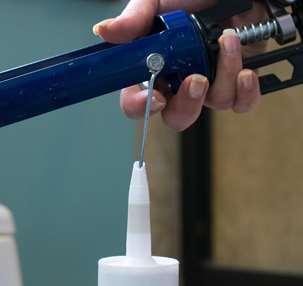 Demonstration of piercing a tube of caulk with caulk gun.