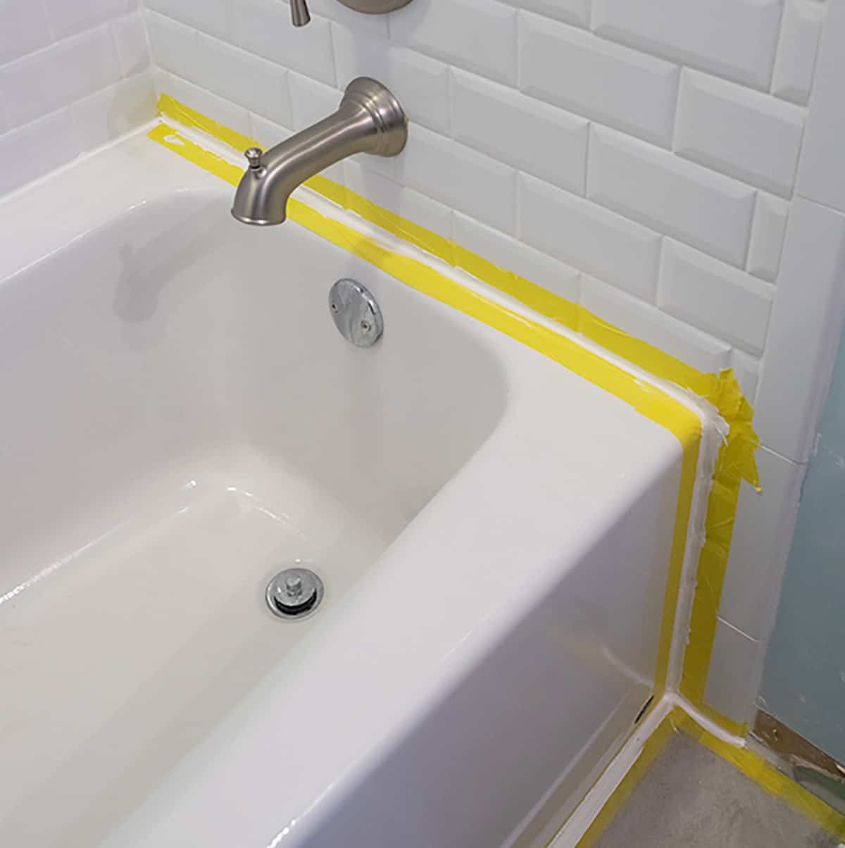 Taping both sides of a caulk seam as example for a straight line of caulk on a bathtub surround.