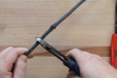Using plier snips to cut an electrical cord.
