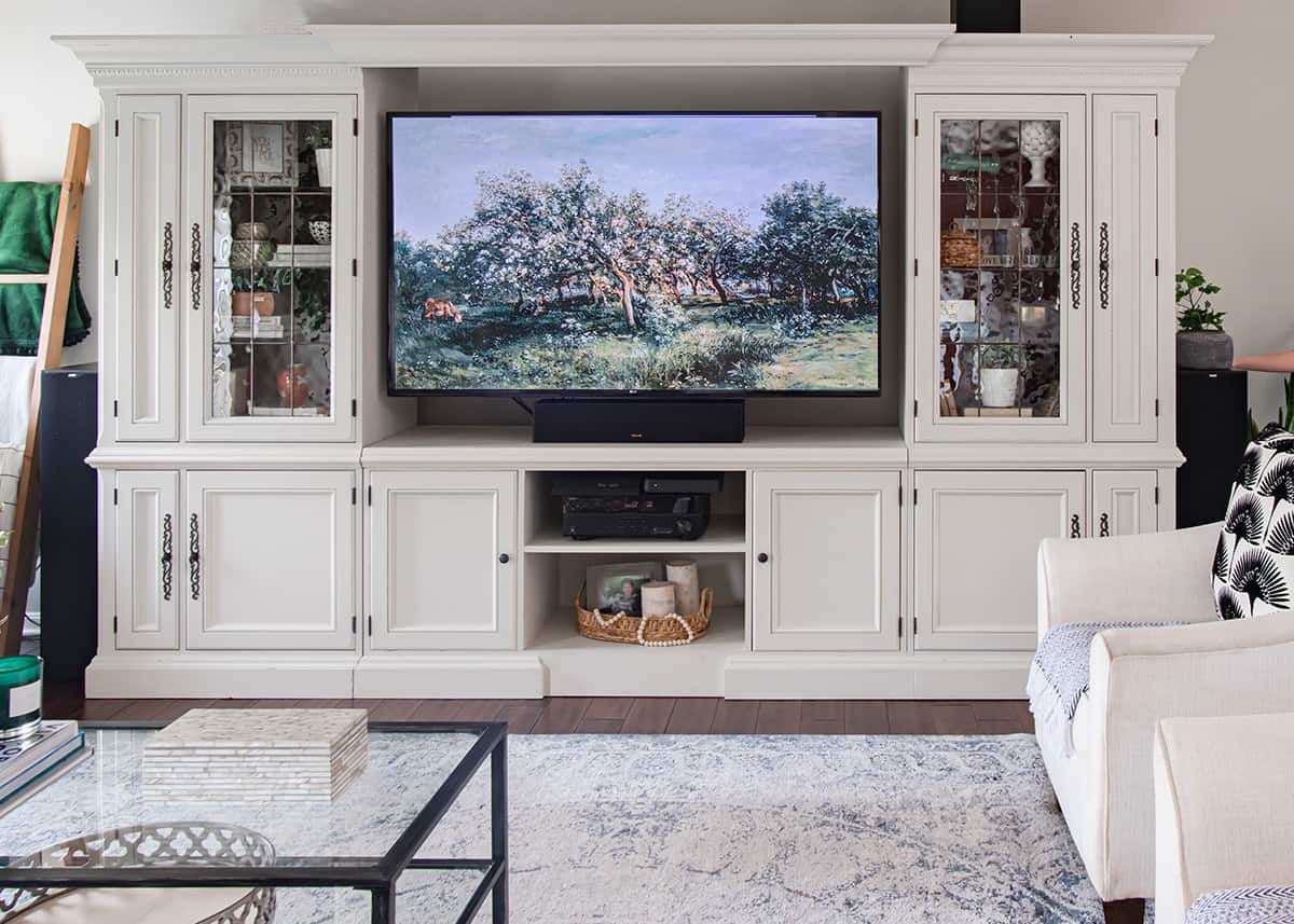 Traditional living room with global accents entertainment center makeover painted in cream.