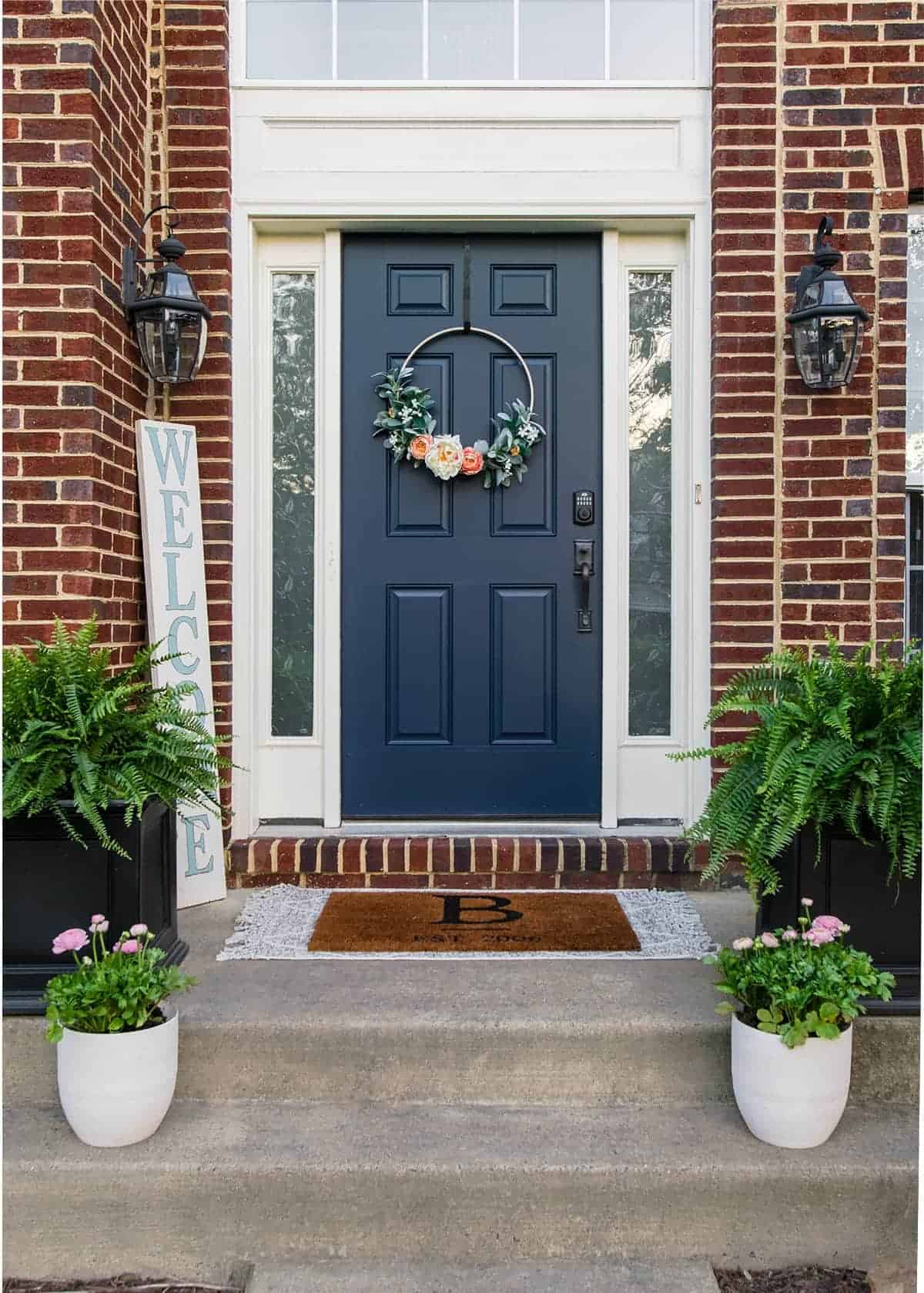 Blue front door on red brick house with planters on either side.