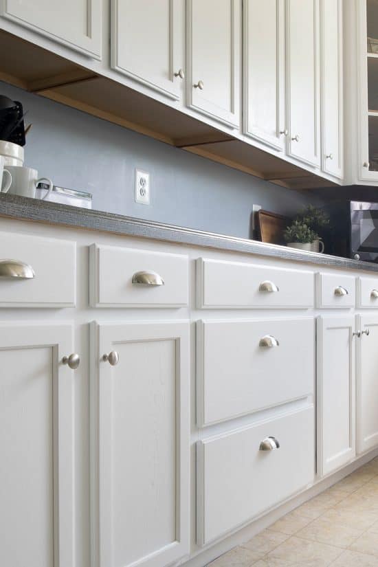 White painted kitchen cabinets with stainless drawer pulls.