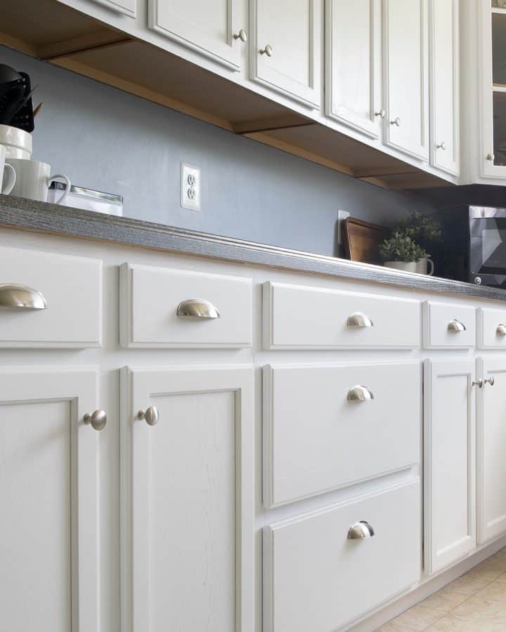 White painted kitchen cabinets with stainless drawer pulls.