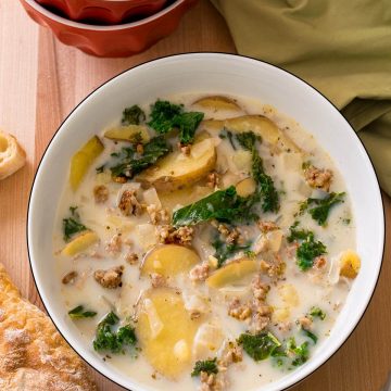 Top down view of Sausage Kale Soup in a red bowl.