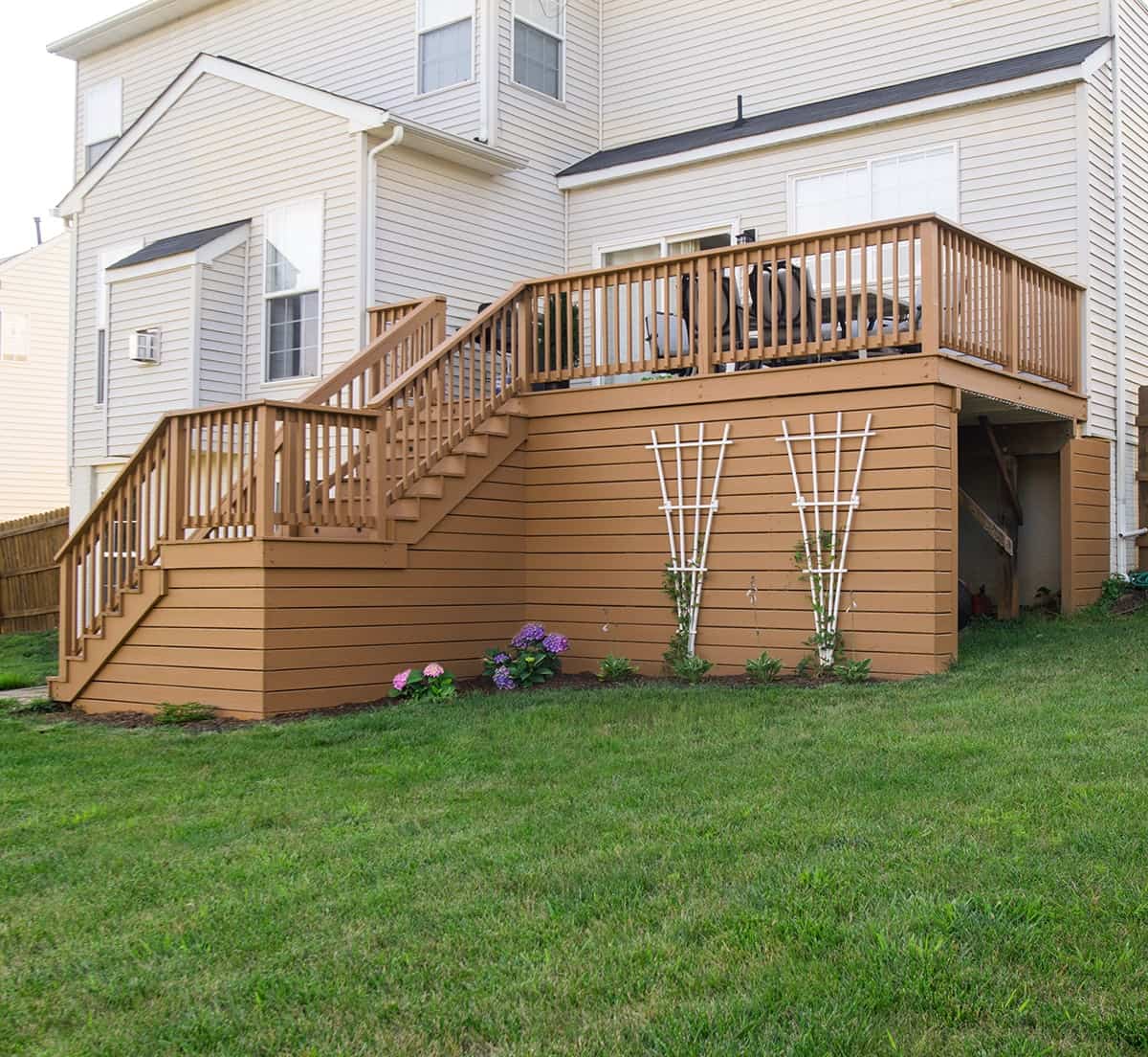 Two level deck with stair case on the back of a house.