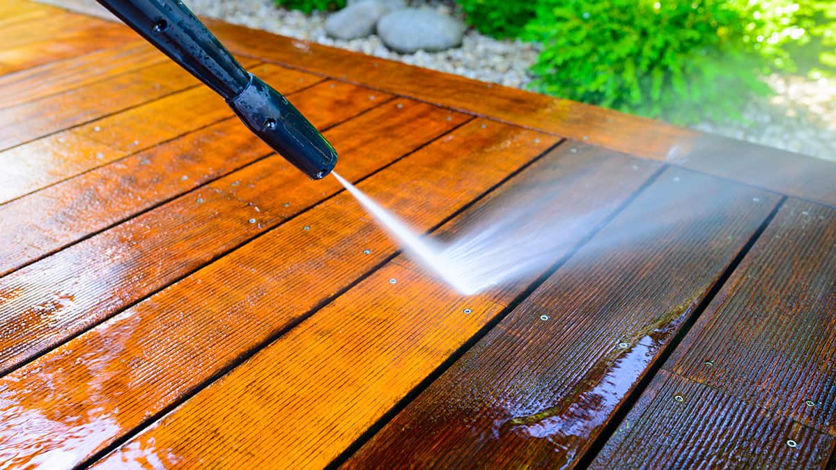 Pressure washing a deck surface.