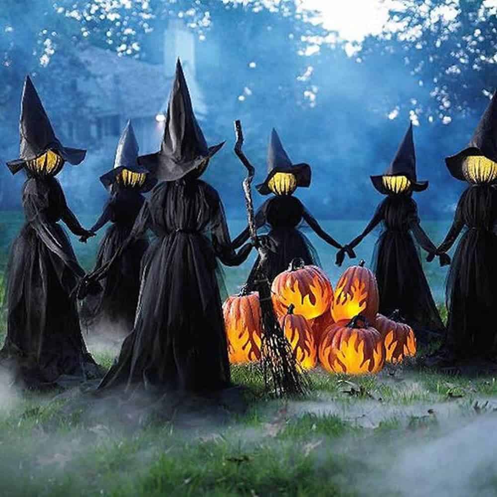 Halloween outdoor decoration consisting on witches' circle holding hands around a pumpkin bonfire.