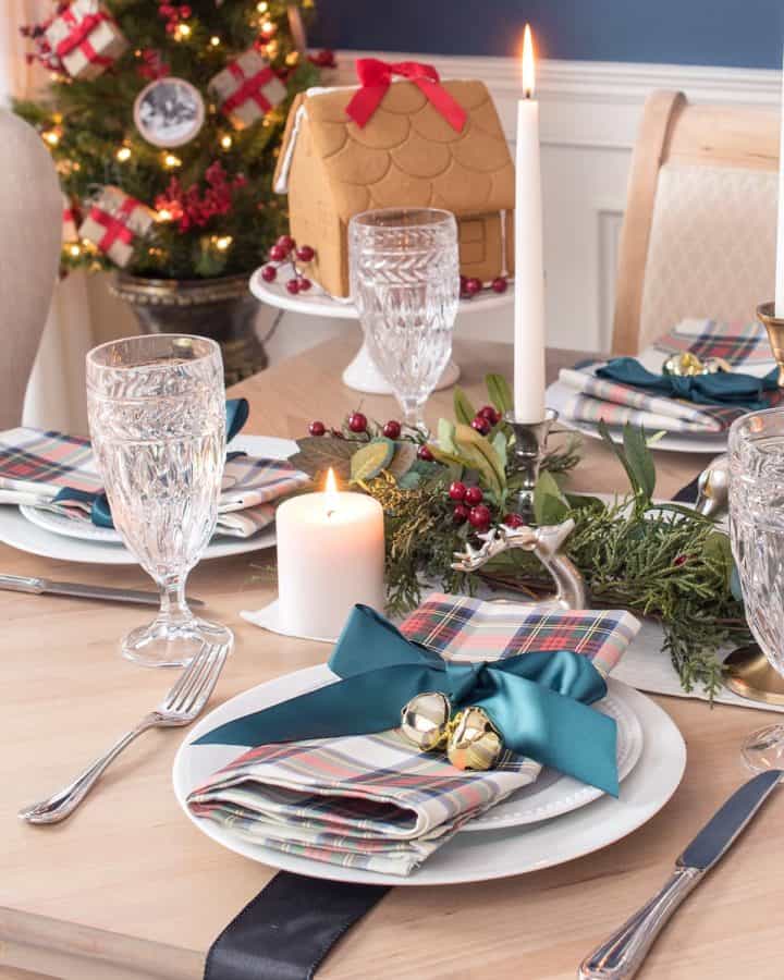 Traditional tartan christmas table decorations with napkins, place settings, and crystal goblets.