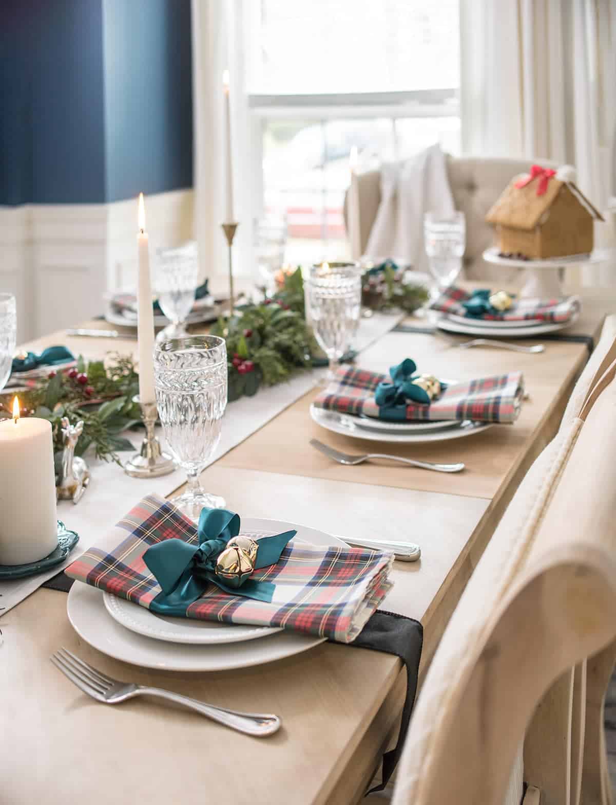 Christmas plaid table settings with a Scottish Tartan theme including dress stewart clan napkins, hunter green ribbon, and jingle bell place holders.