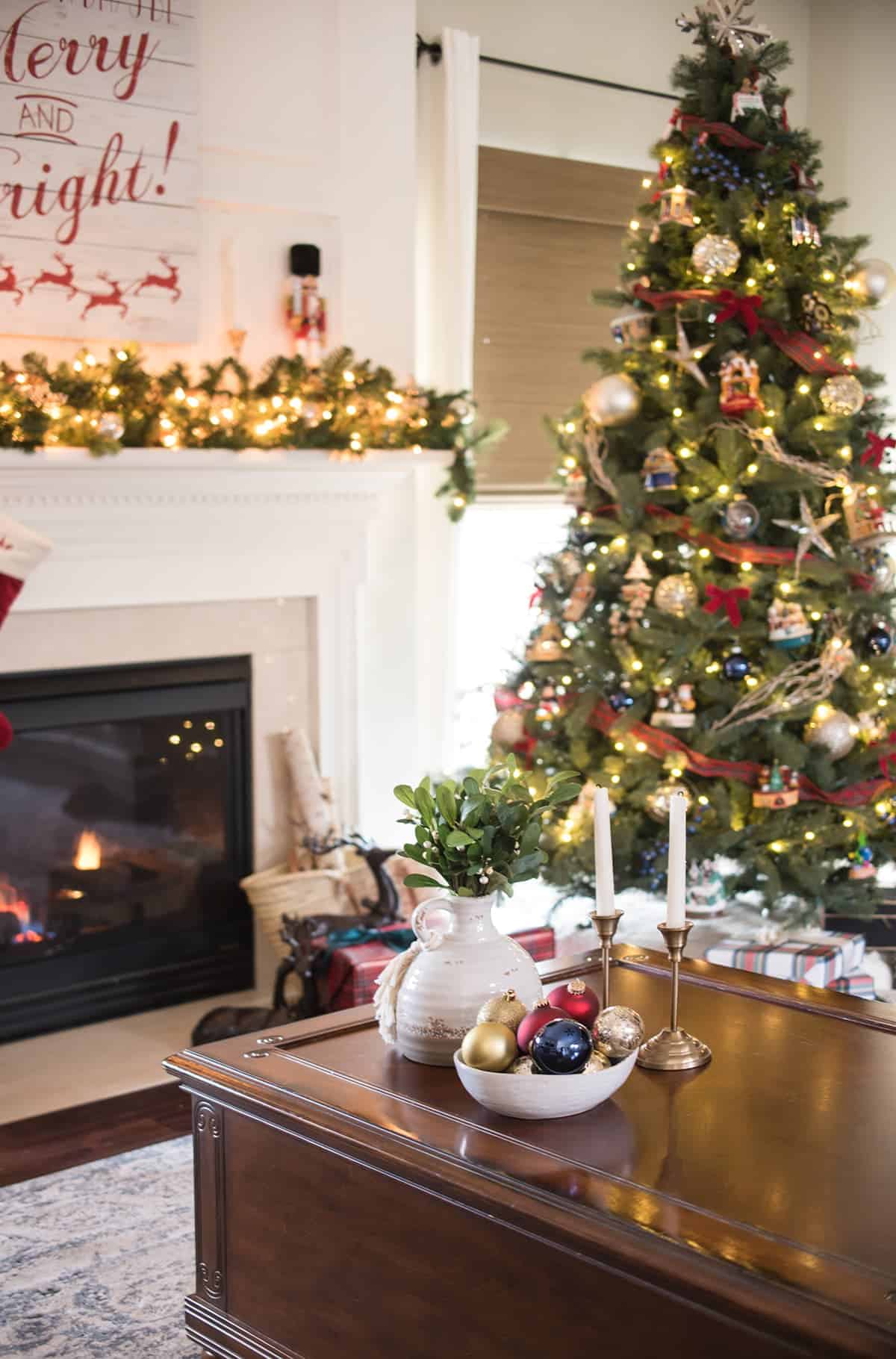 Family room decorated for Christmas, close up of coffee table with twinkling Christmas tree in the background.