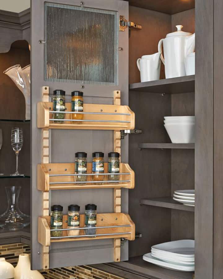 Spice rack hung on the inside of a cabinet door.