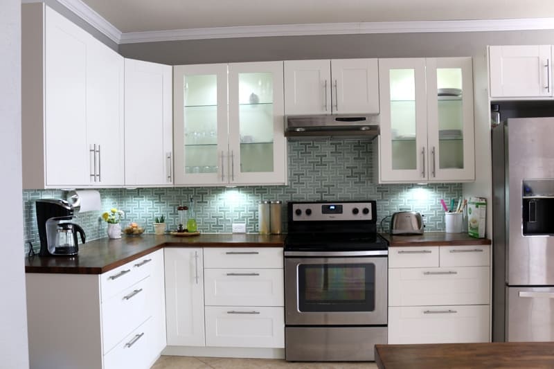 LED Under cabinet puck lighting for kitchen. Turquoise back splash and white cabinets. Minimalist modern decor elements.