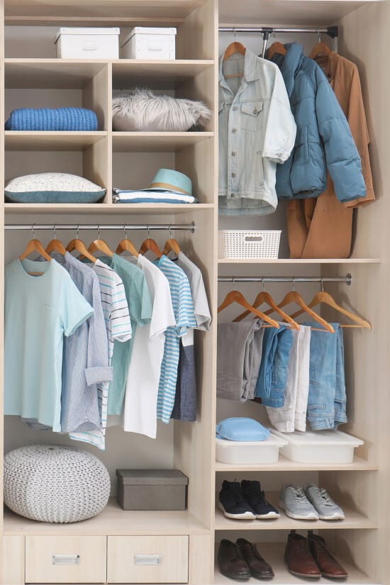 Closet Organization with blue shirts and pants and cubbies.