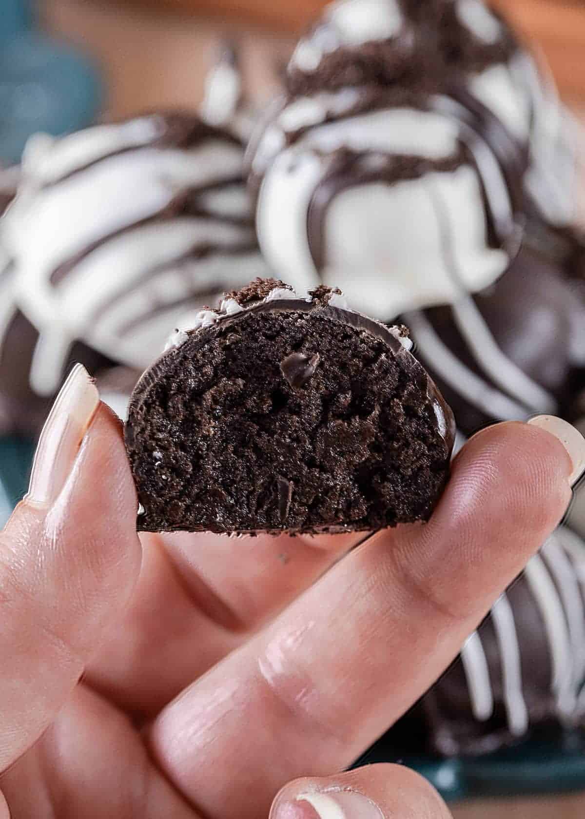 An oreo cookie ball cut in half to show texture of the oreo filling