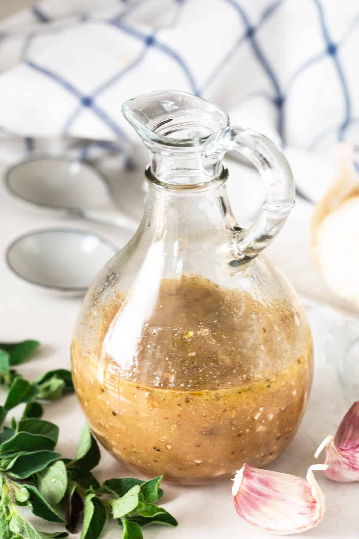 Homemade Greek dressing in a bottle on a table.