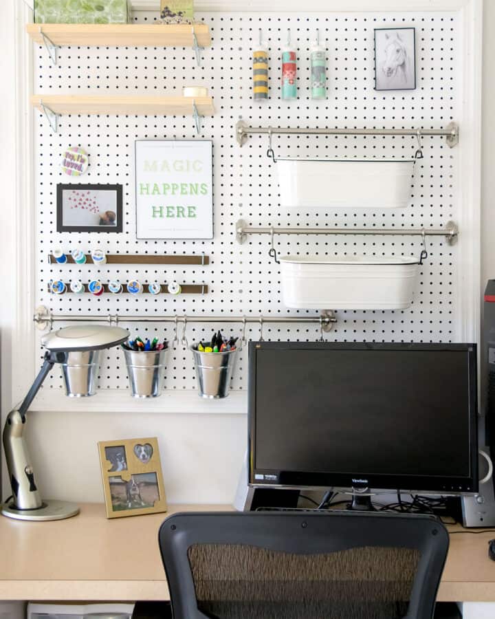 Desk area with large pegboard for craft and office supplies.