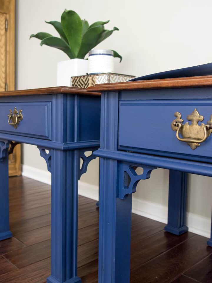 Two blue painted side tables on dark brown hardwoods.