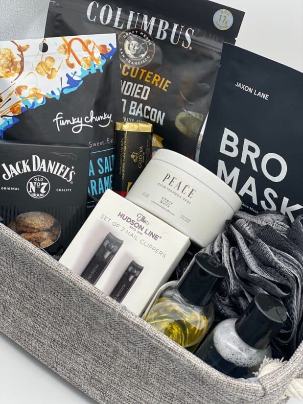 Contents of a man's gift basket with snacks and spa items.