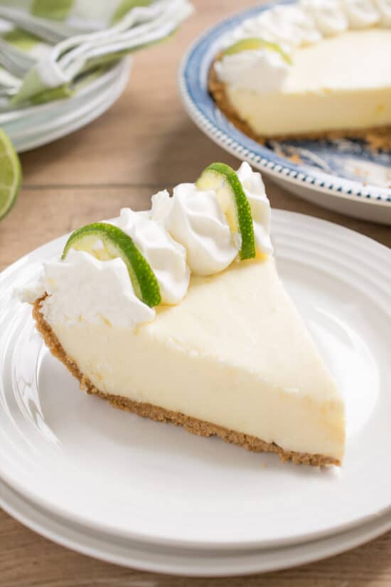 Slice of key lime pie on a white plate.