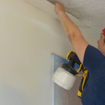 Woman repairing textured ceiling with plaster falling down.