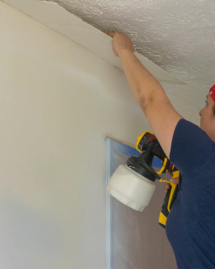 Woman repairing textured ceiling with plaster falling down.