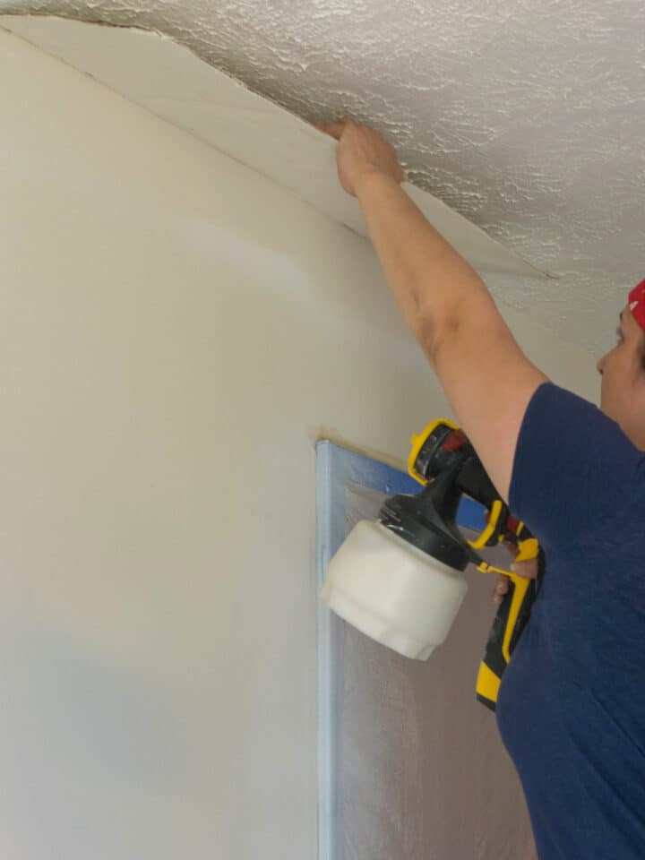 Woman repairing textured ceiling with plaster falling down.