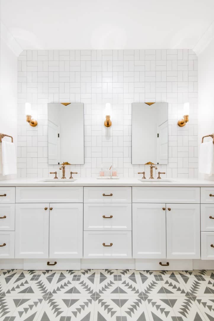 White bathroom with basket weave subway tile and patterned floor.