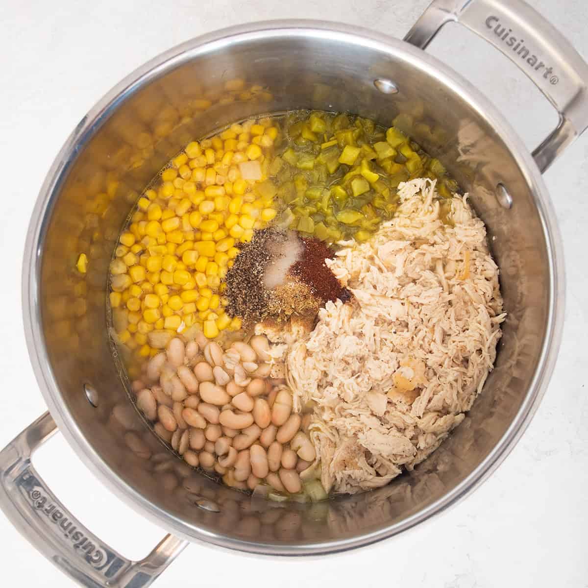 White Chicken chili soup with the ingredients piled into a soup pot.