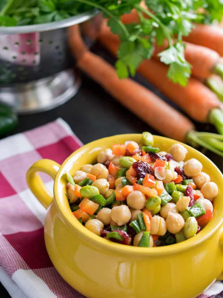 Delicious Summer Chickpea Salad consisting of delicious chopped salad with lots of veggies, cranberries, and a tangy vinaigrette dressing.