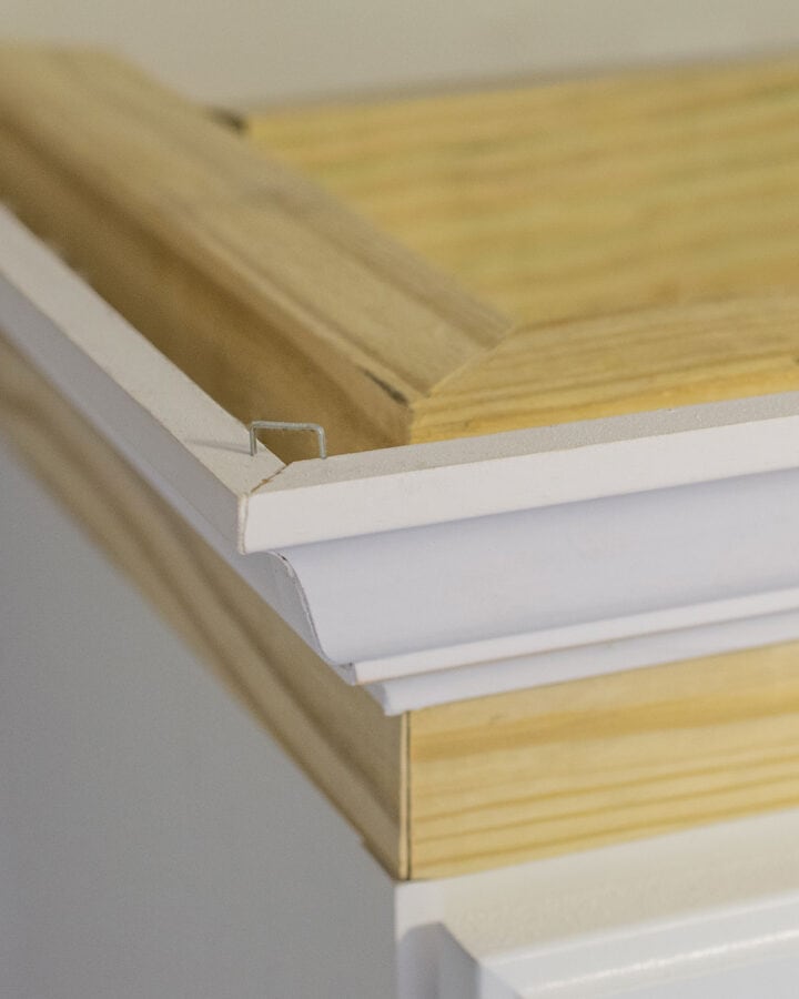 Closeup of crown molding corner on edges of cabinets.
