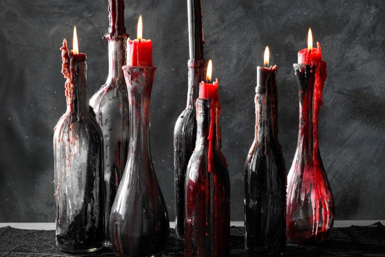 Wine bottles made with dripping candle wax in red and black.