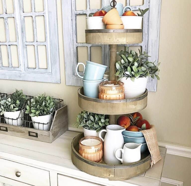 2-tiered wooden bucket style tiered tray styled with classic white and light blue kitchen accent, candles and fresh peaches