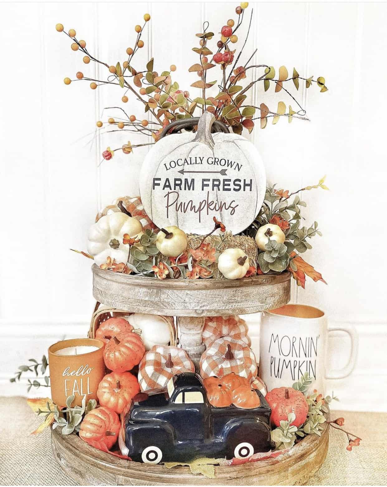 Rustic tiered tray styled for fall with mini pumpkins, eucalyptus sprigs, and fall berries