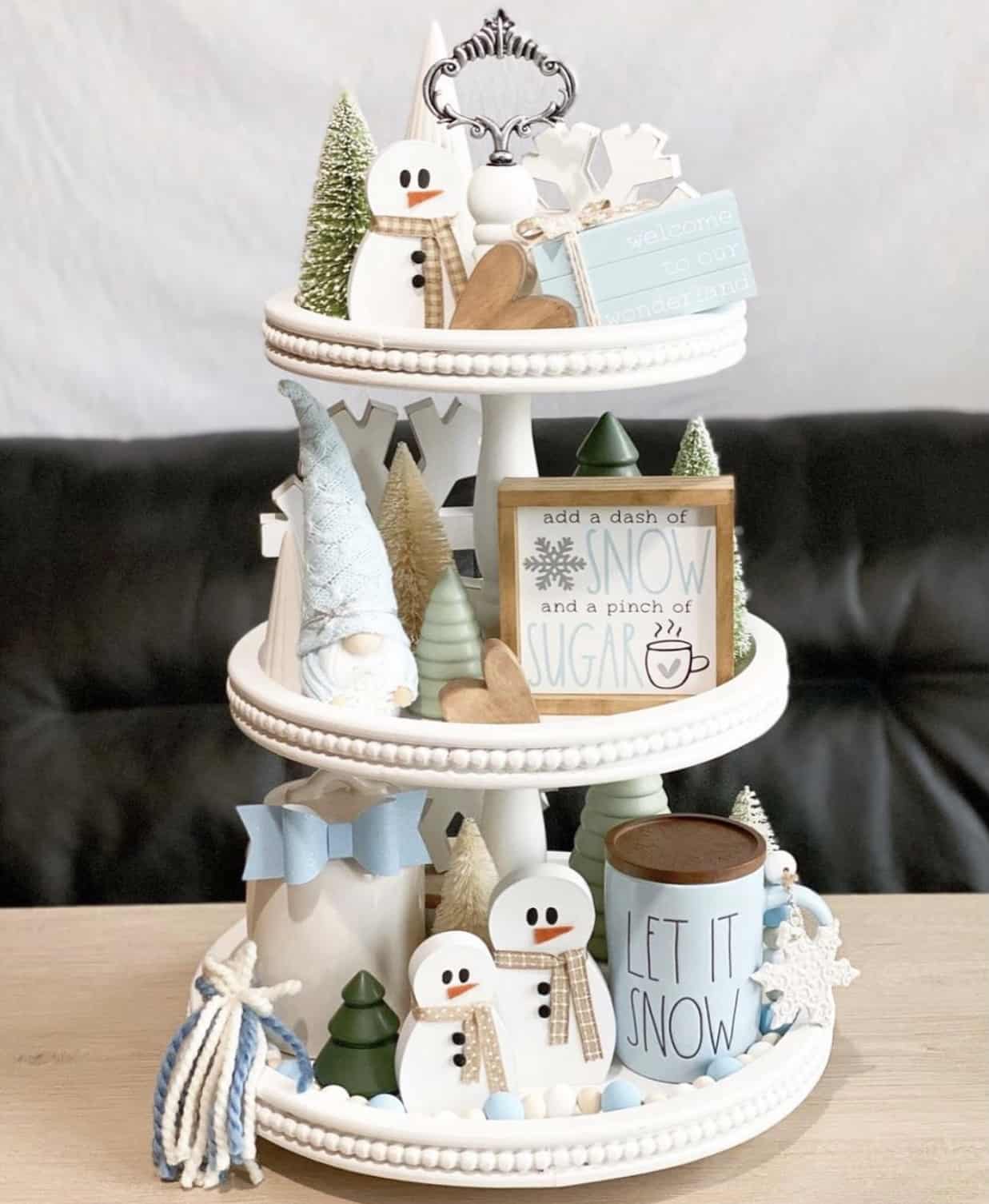 3-tiered white cake stand themed with winter snowman figures, mini Christmas trees and snowflakes