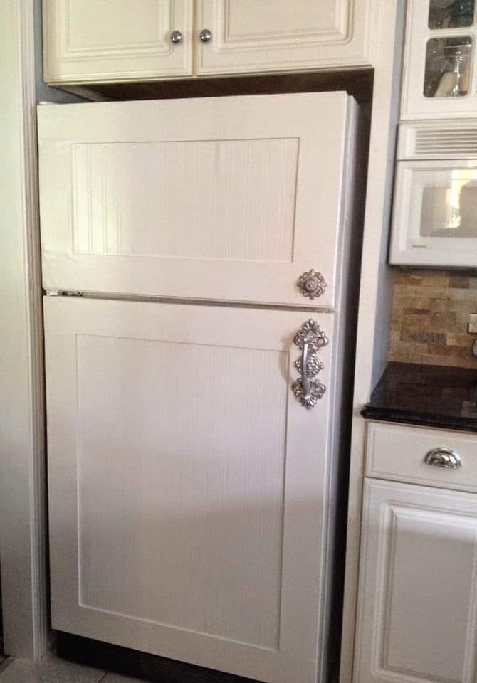 White refrigerator with beadboard on the door.